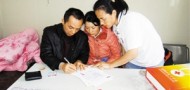 Ye's parents filling out the forms, courtesy of Shenzhen Evening News.